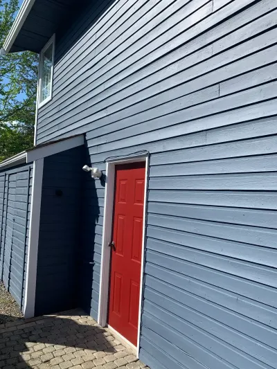 After: Side of home with red door and navy siding, Brackendale Squamish BC