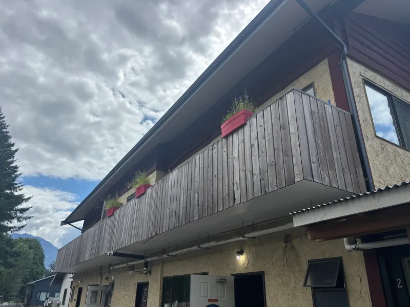 Before: Upper balcony with railing and planters along a siding and wall, Brackendale, Squamish, BC