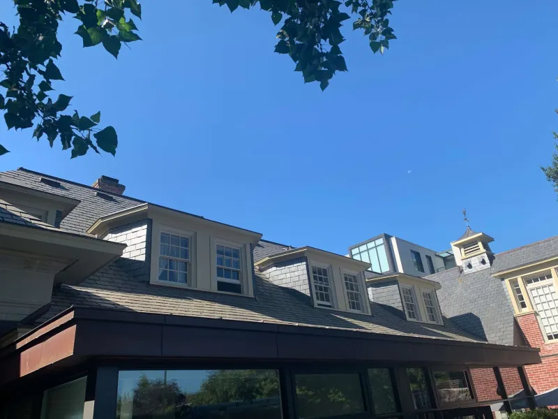 After: Wide view of painted dormers, roofline and fascia against a clear sky, Central - Granville St, Vancouver, BC