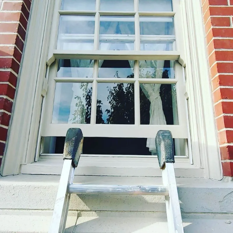 After: Front window with freshly painted trim and sash, ladder resting against sill, Central - Granville St, Vancouver, BC