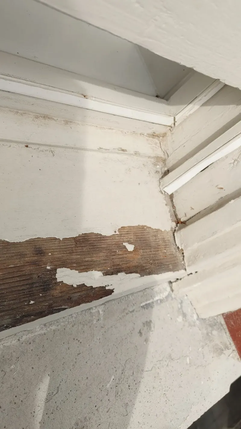 Before: Close view of a window sill corner with peeling paint and rot before repair, Central - Granville St, Vancouver, BC