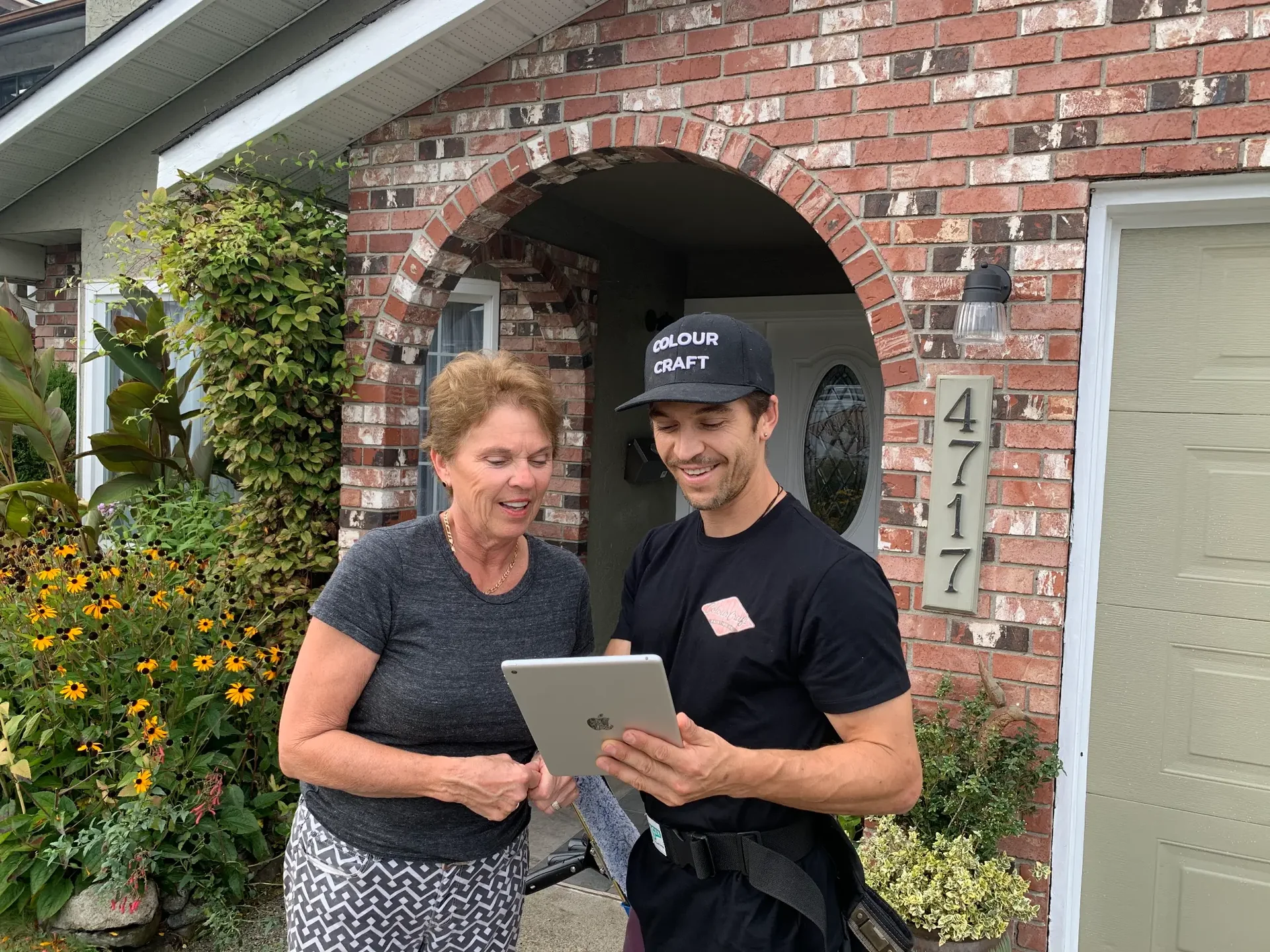 Colour Craft Painting, painter showing estimate to homeowner on iPad at front door