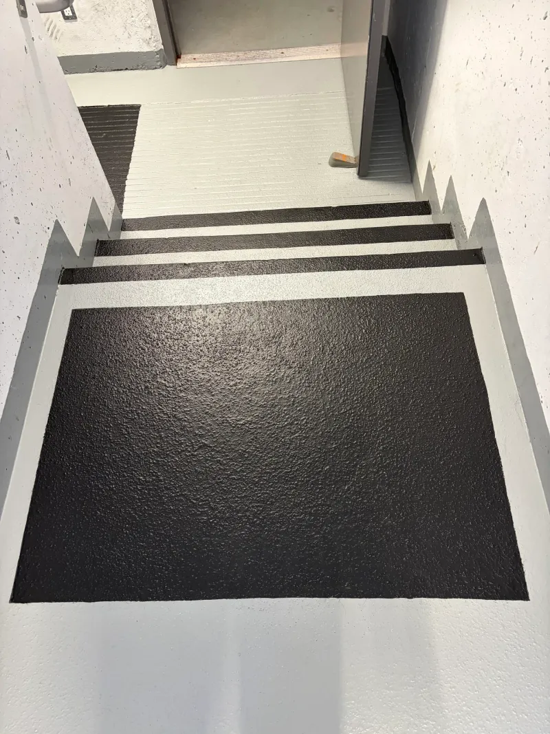 After: Stair landing and treads outside a doorway with fresh light and black non-slip paint, Downtown BC, Squamish, BC