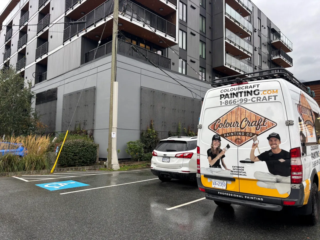 After: Wide view of repainted building front elevation above parking area, Downtown, Squamish, BC