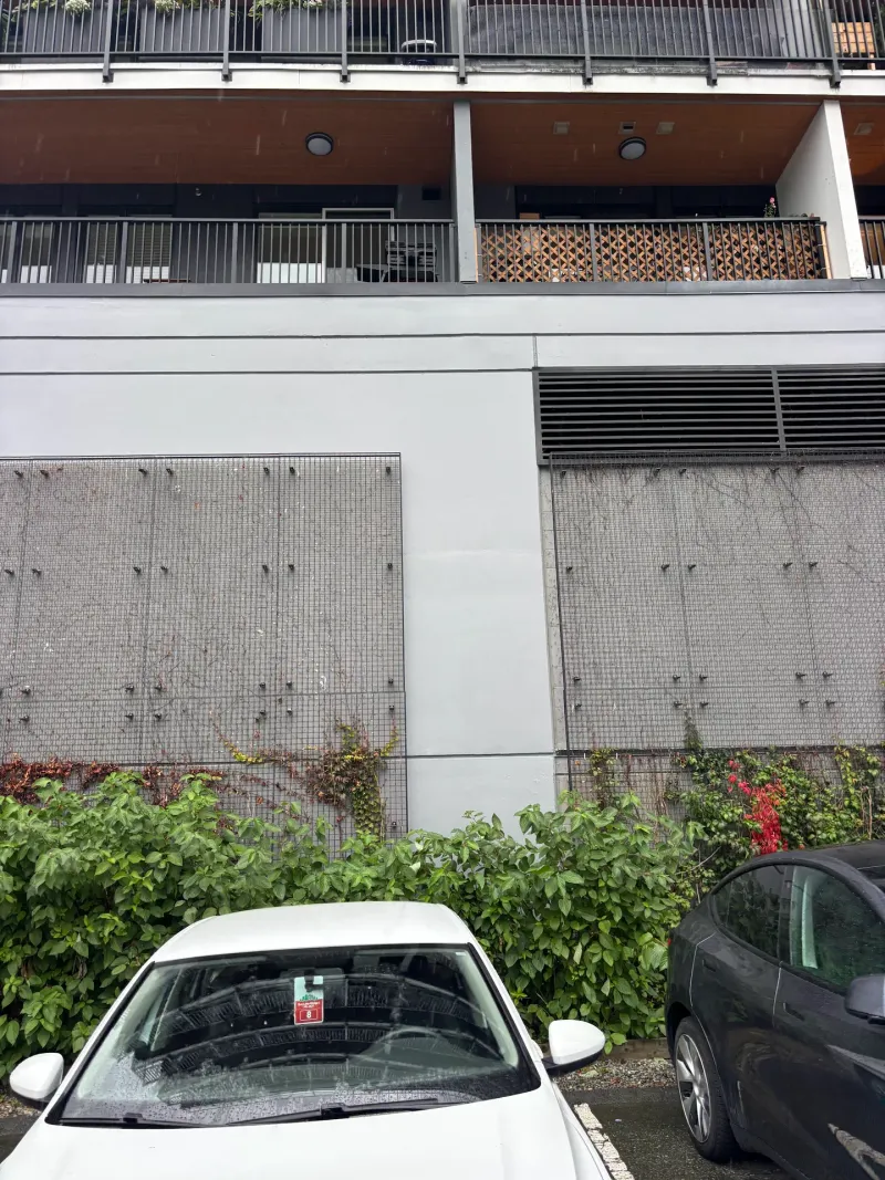 After: Freshly painted wall section with screens and vents above parked cars, Downtown, Squamish, BC