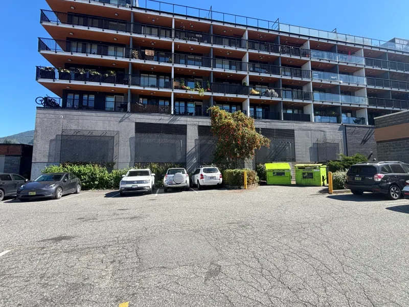 Before: Wide view of building front elevation above parking area, Downtown, Squamish, BC