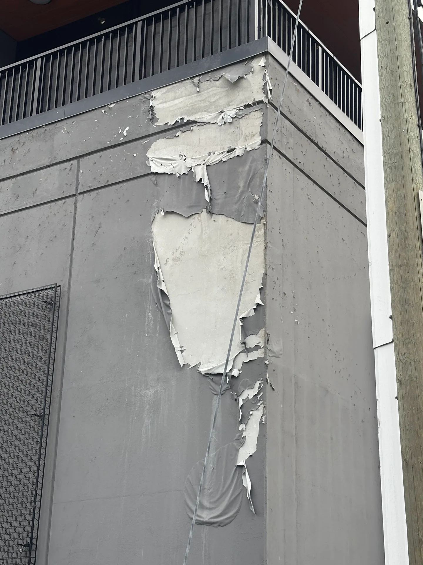 Before: Wall corner with large area of peeling paint, Downtown, Squamish, BC