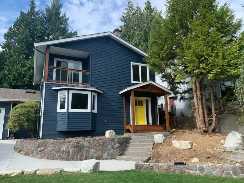 Completed exterior repaint, navy siding and yellow door, Squamish BC exterior painters