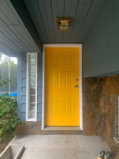 After: bold yellow front door with steel blue siding, Garibaldi Highlands Squamish