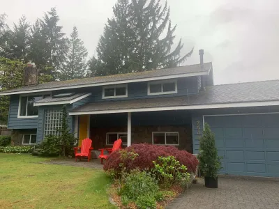 After: front, steel blue siding with yellow door, Garibaldi Highlands Squamish