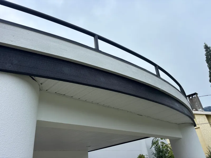 After: Close view of a curved balcony railing and the underside of a covered entry roof, Garibaldi highlands, Squamish, BC