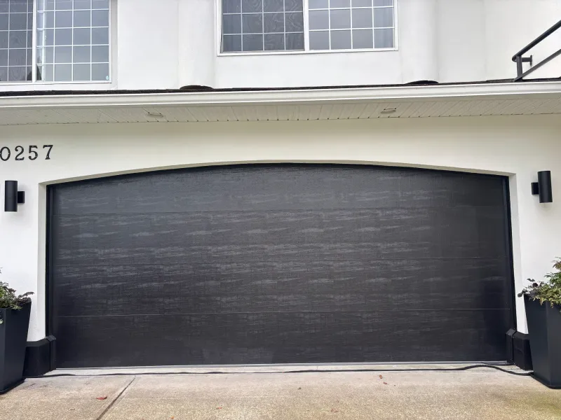 After: Straight-on view of a double garage door with flanking planters and upper story windows, Garibaldi highlands, Squamish, BC