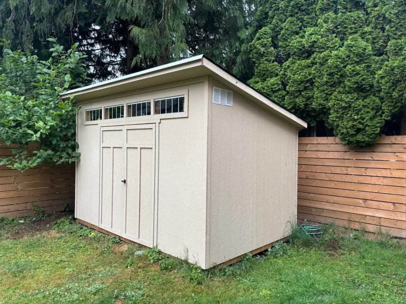Before: Backyard storage shed with a paneled door, transom windows, and a sloped roof, Garibaldi highlands, Squamish, BC