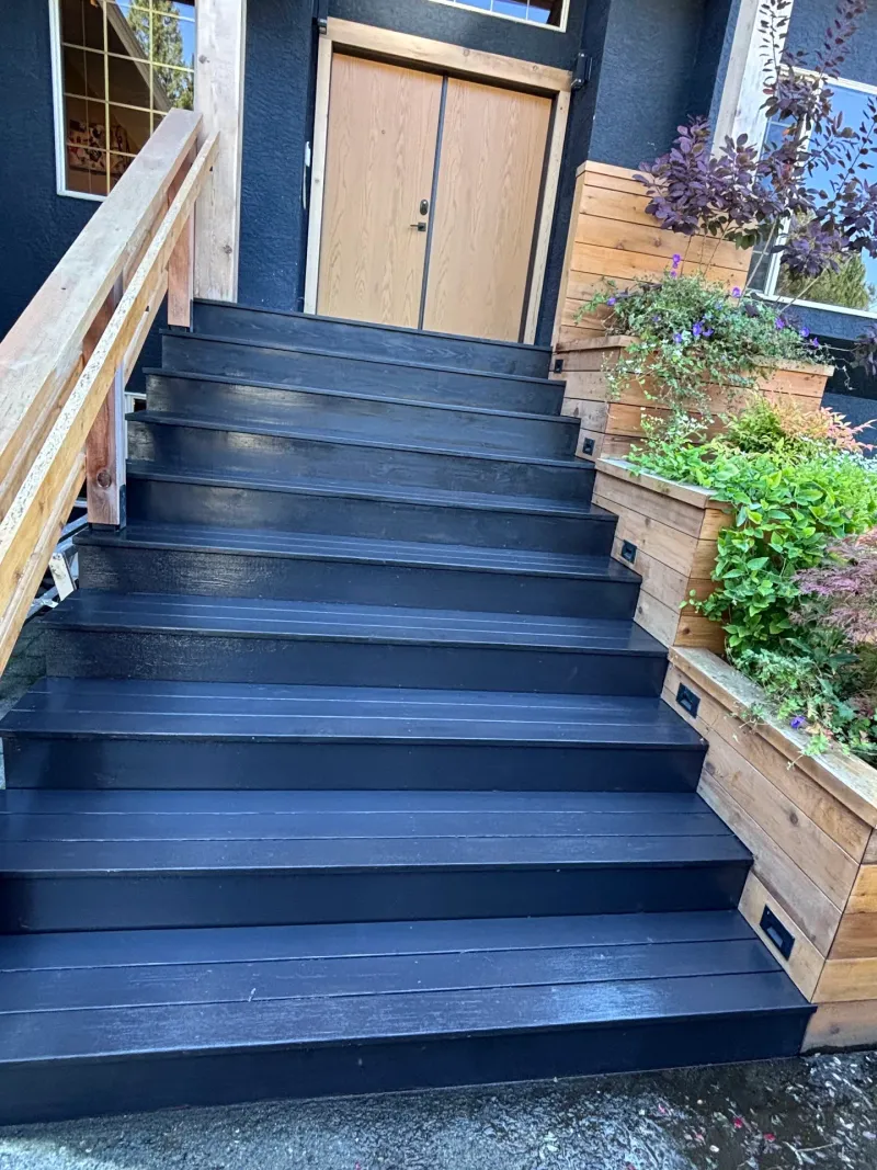 After: front entry staircase with freshly painted dark treads and risers, railings and planter boxes with flowers, Highlands, Squamish, BC