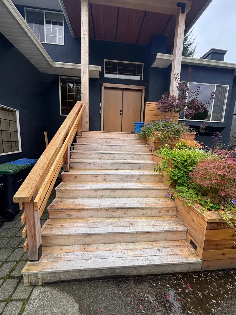 Before: Front elevation of the house showing covered entry porch, staircase, railings, and planter boxes, Highlands, Squamish, BC