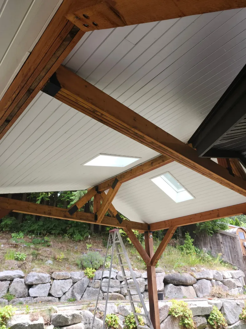 After: Painted white patio ceiling with beams and two skylights over a rear deck, - Isabella Rd, Salt Spring Island, BC