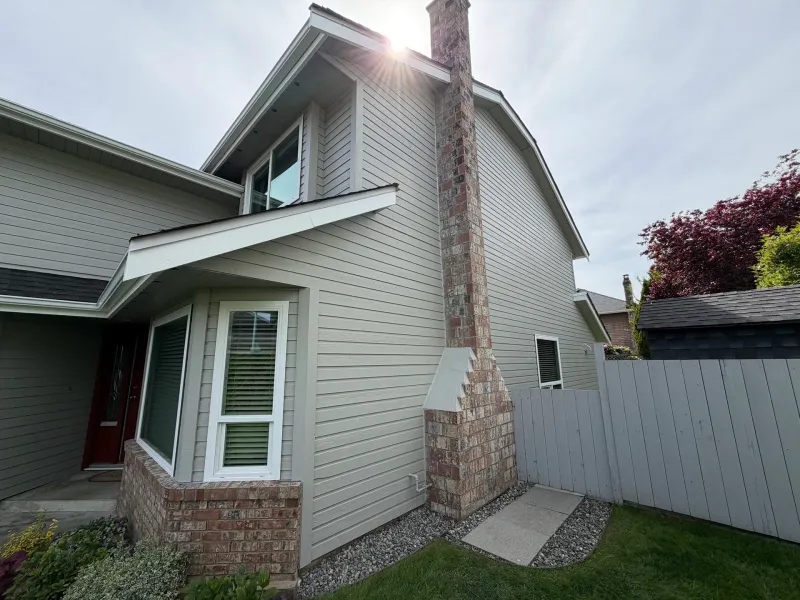 After: Side elevation with chimney, bay window and red entry door partially visible, Richmond, BC