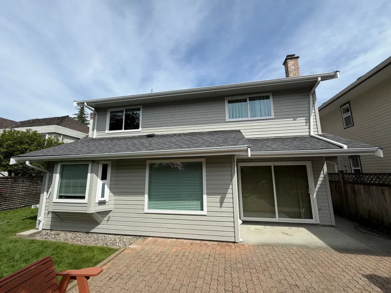 After: Repainted rear elevation with large windows, sliding door and covered patio, Richmond, BC