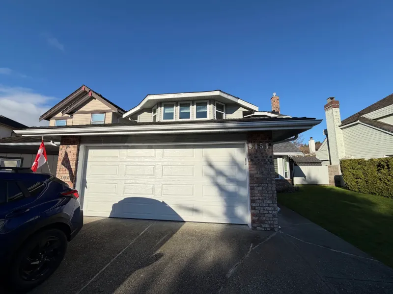 Before: Two-car garage door with pillar accents and gabled roofline above, Richmond, BC