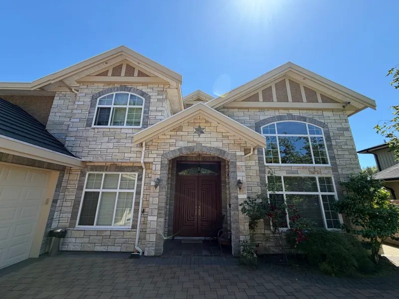 After: Front entry elevation with double door, stone facade, gables and windows, Seafair, Richmond, BC