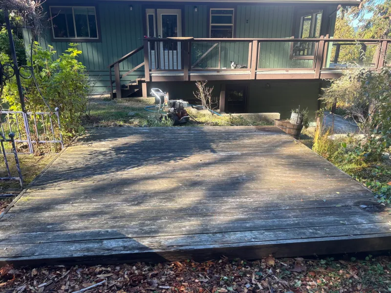 Before: Rear elevation of house with green siding, deck, stairs, and railing, Souther Salt Spring. Isabella Point / Roland Rd, BC