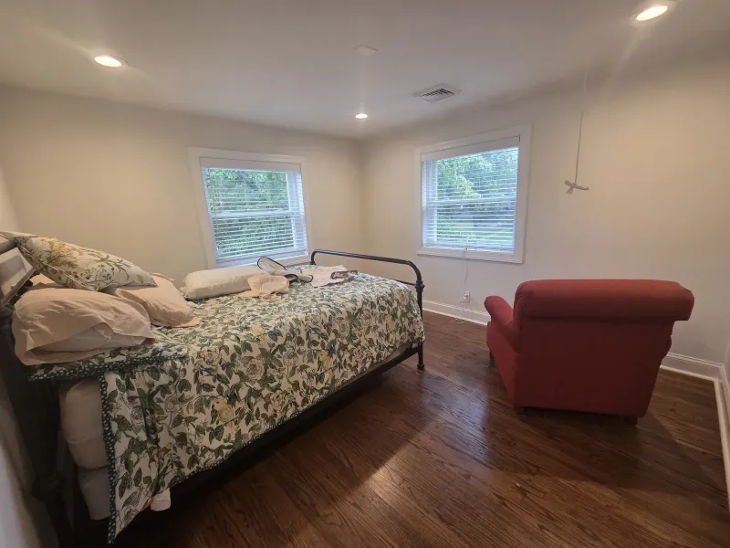 Before: Bedroom with white walls and trim, two windows, flooring before painting, Springfield, PA
