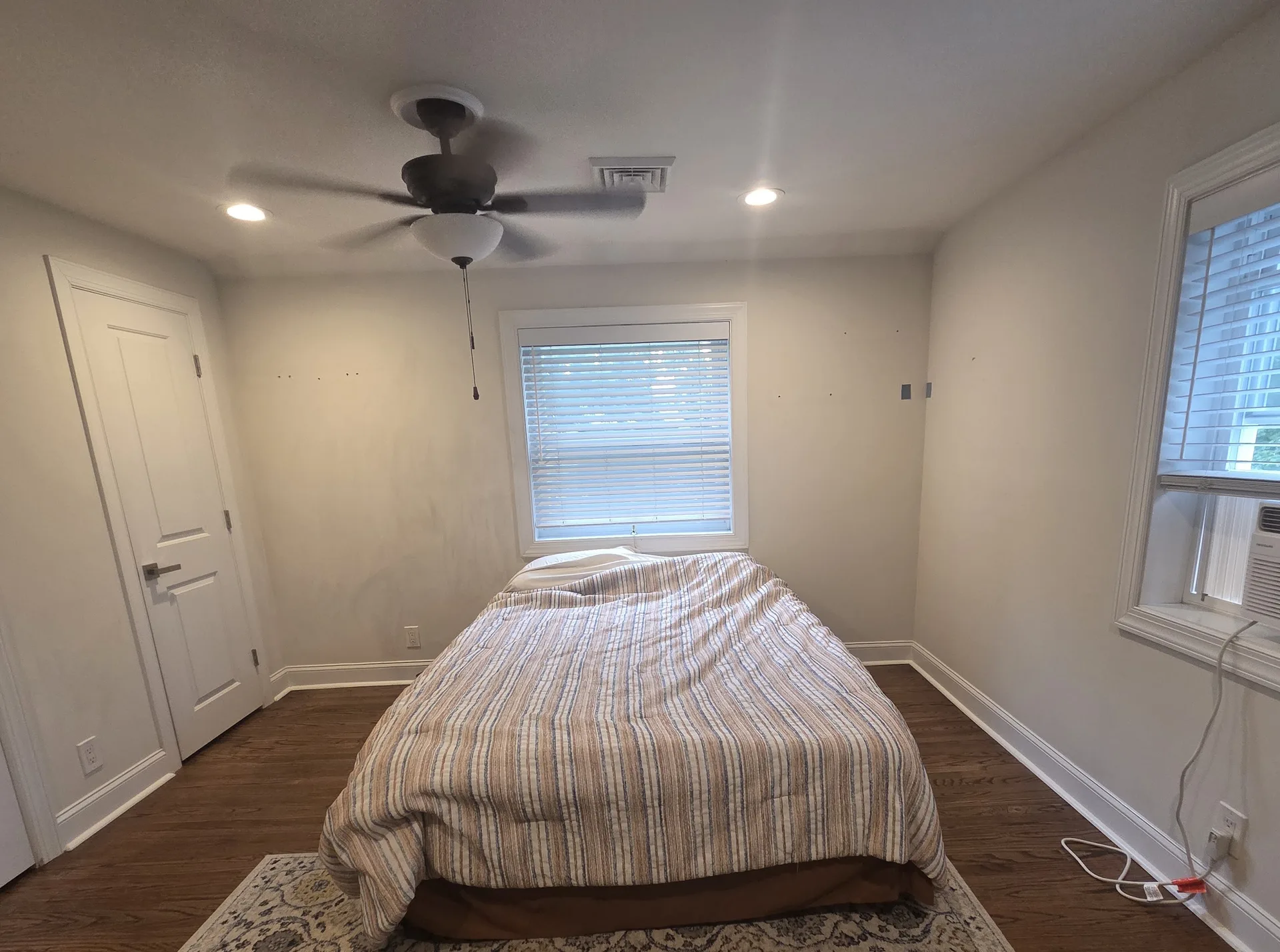 Before: Bedroom with white walls, closet door, ceiling fan, and window before repainting, Springfield, PA
