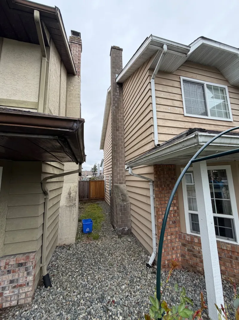 Before: Narrow side yard view with siding, chimney, and gutter along the eave, Steveston, Richmond, BC