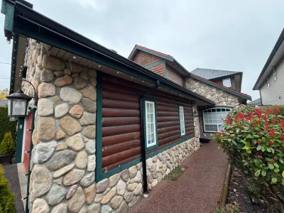 Before front-side view of weathered log siding on this Steveston home