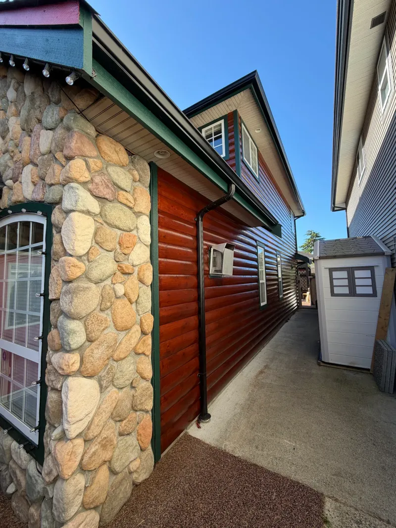 After: Side yard walkway along stone and log siding wall with a mounted unit, Steveston, Richmond, BC