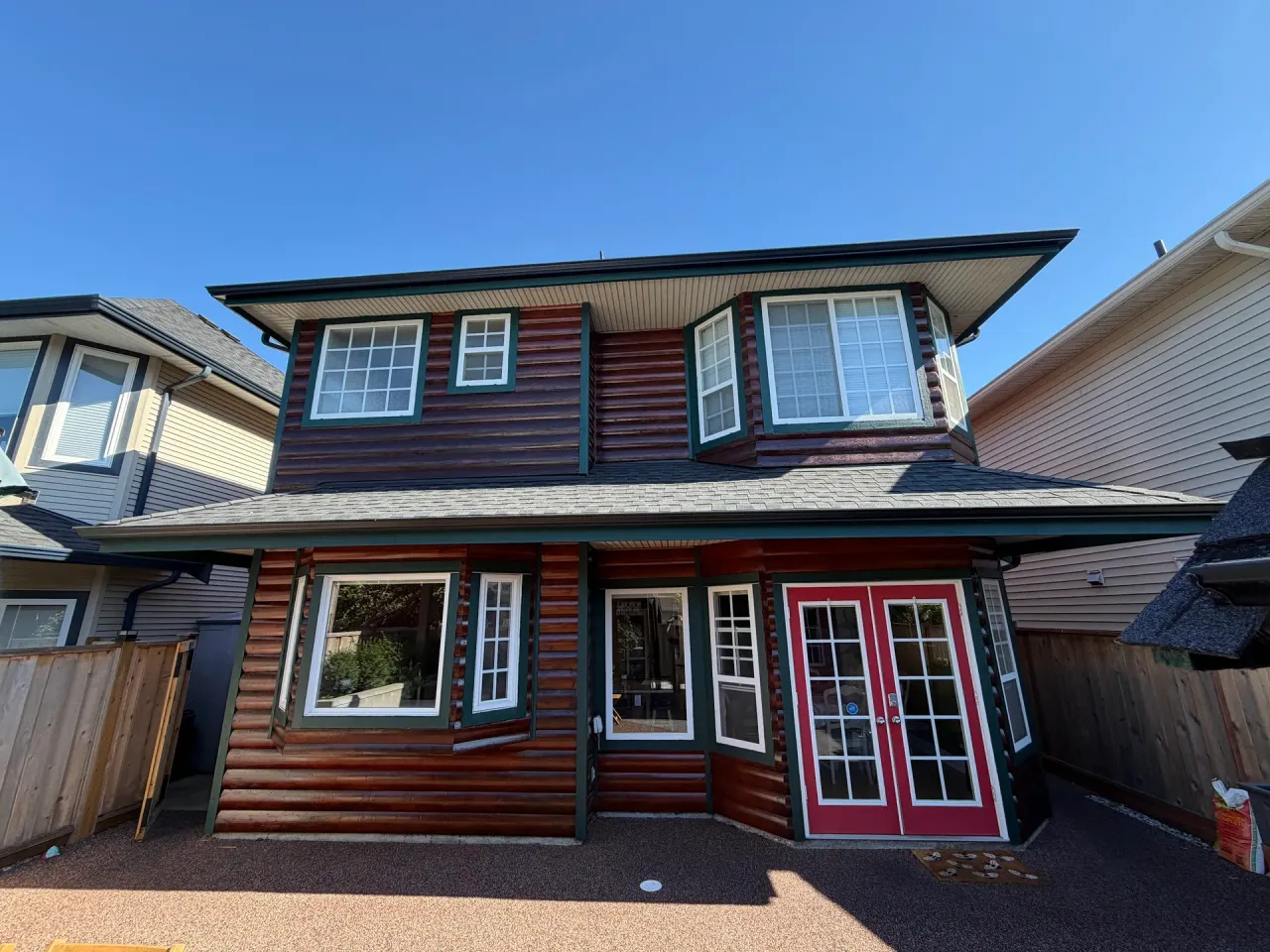 After: Rear elevation with log siding, bay windows and red French doors, Steveston, Richmond, BC