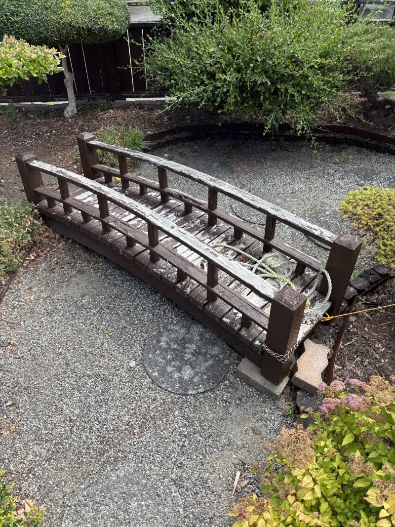 Weathered garden footbridge with peeling finish before refinishing at a Steveston home in Richmond, BC