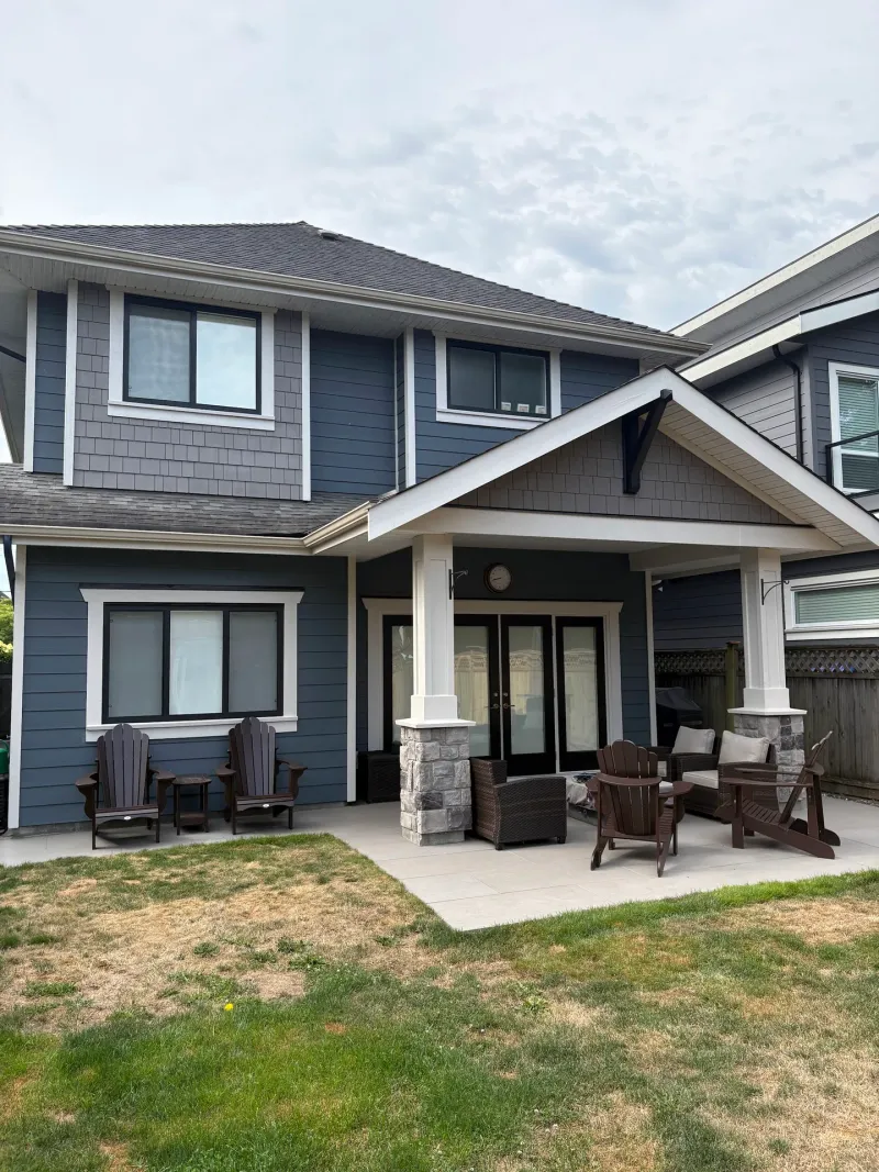 After: Rear elevation of two-story house with covered patio, columns, windows, and French doors, Steveston, Richmond, BC