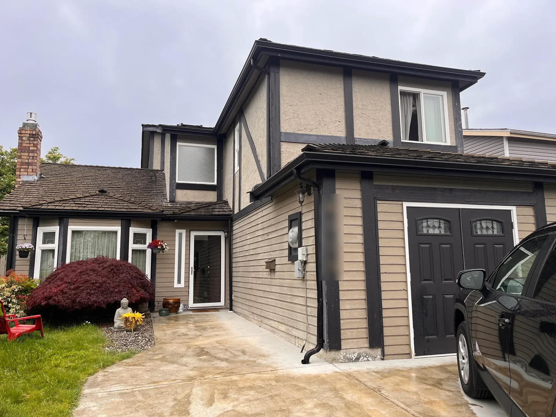 Before: Front elevation of a two-story house with garage, siding, trim, and covered entry before painting, Steveston, Richmond, BC