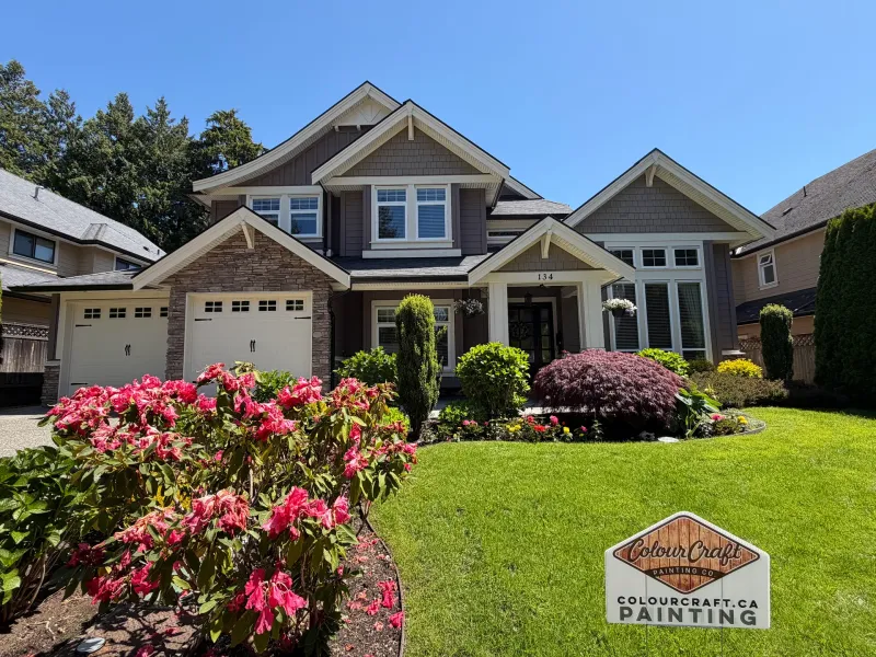 After: Front of two-story house with double garage doors, stone accents, covered entry, and landscaped garden, Tsawwassen, Delta, BC