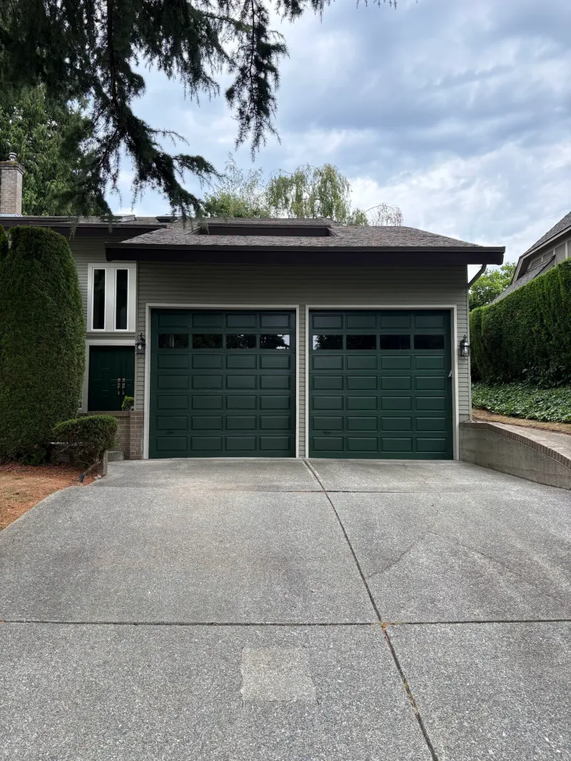 After: Front elevation of house with two-car garage doors, siding and driveway, Tsawwassen, Delta, BC