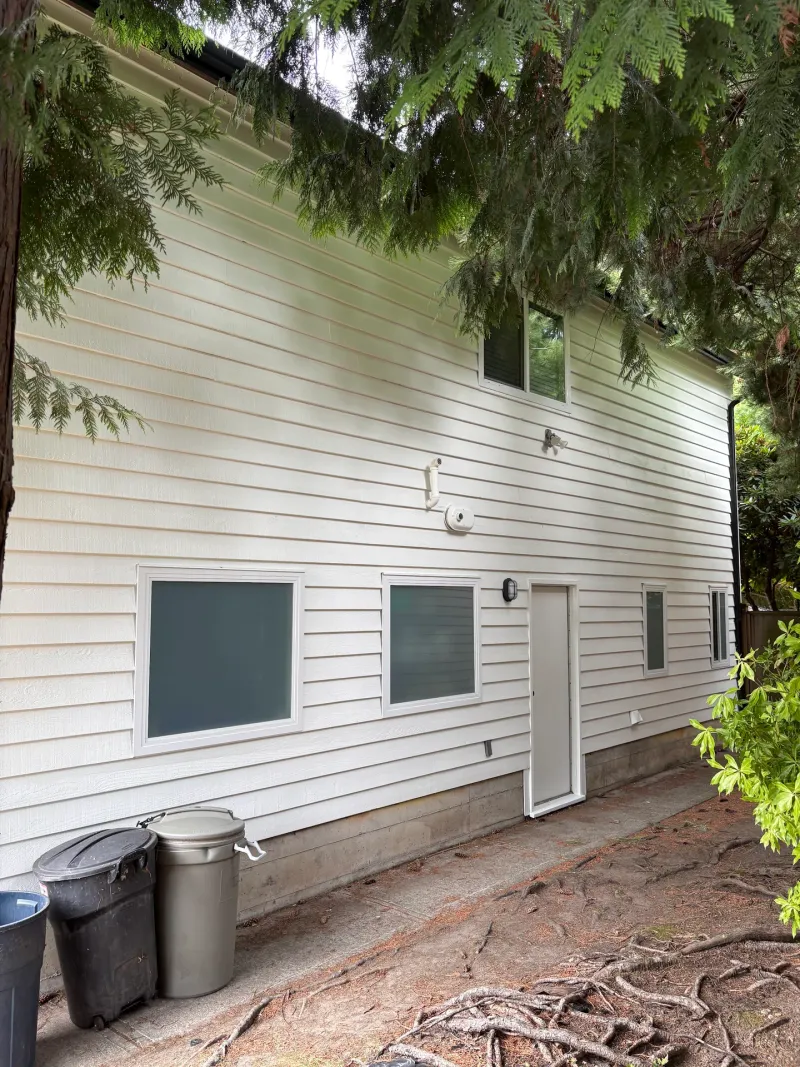 After: Side elevation of house with white siding, windows and door after painting, Tsawwassen, Delta, BC