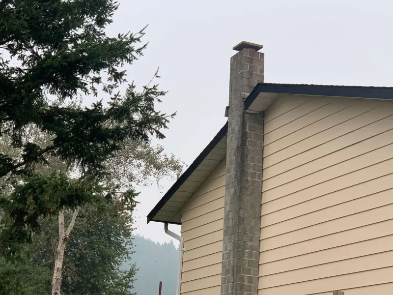 After: Gable end of house with chimney and freshly painted siding and trim, - Valley Cliff, Squamish, BC
