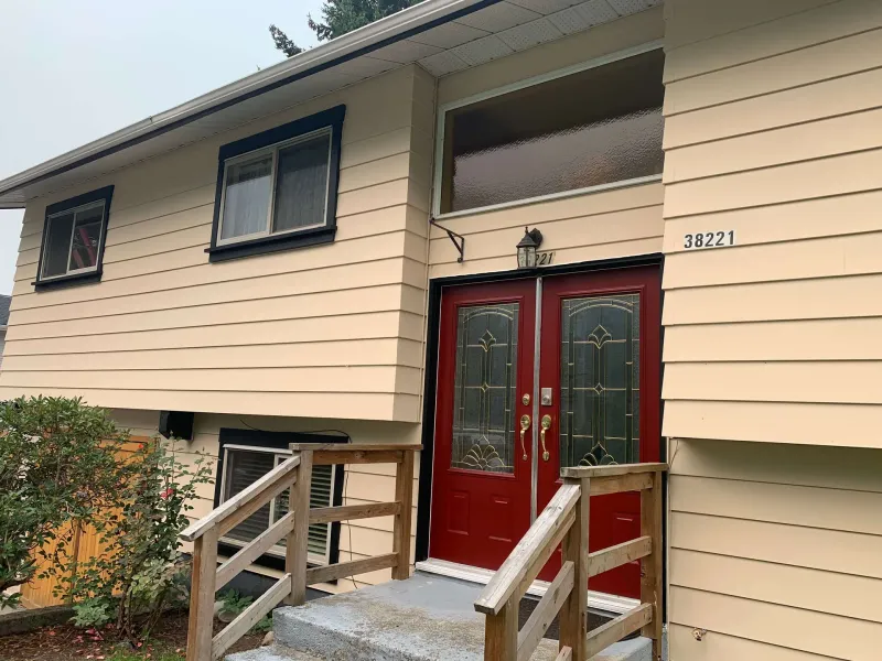 After: Front entry with red double doors, stairs, and freshly painted siding and trim, - Valley Cliff, Squamish, BC
