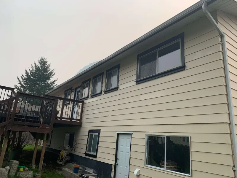 Before: Back of house with deck, windows, and door before painting, - Valley Cliff, Squamish, BC