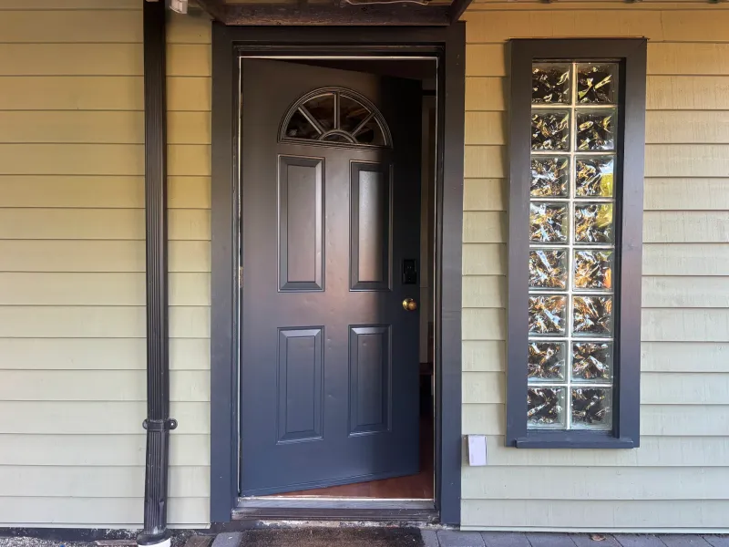 After: Front entry door with arched window panel, open beside a glass block sidelight, Vancouver, West Vancouver, BC