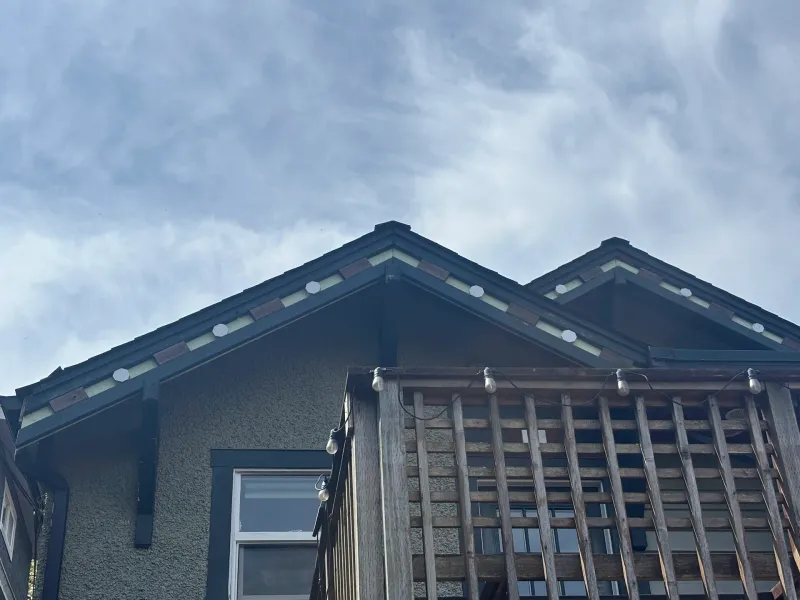 Before: Close angle of gable eave, fascia trim and upper deck railing against sky, Vancouver, West Vancouver, BC