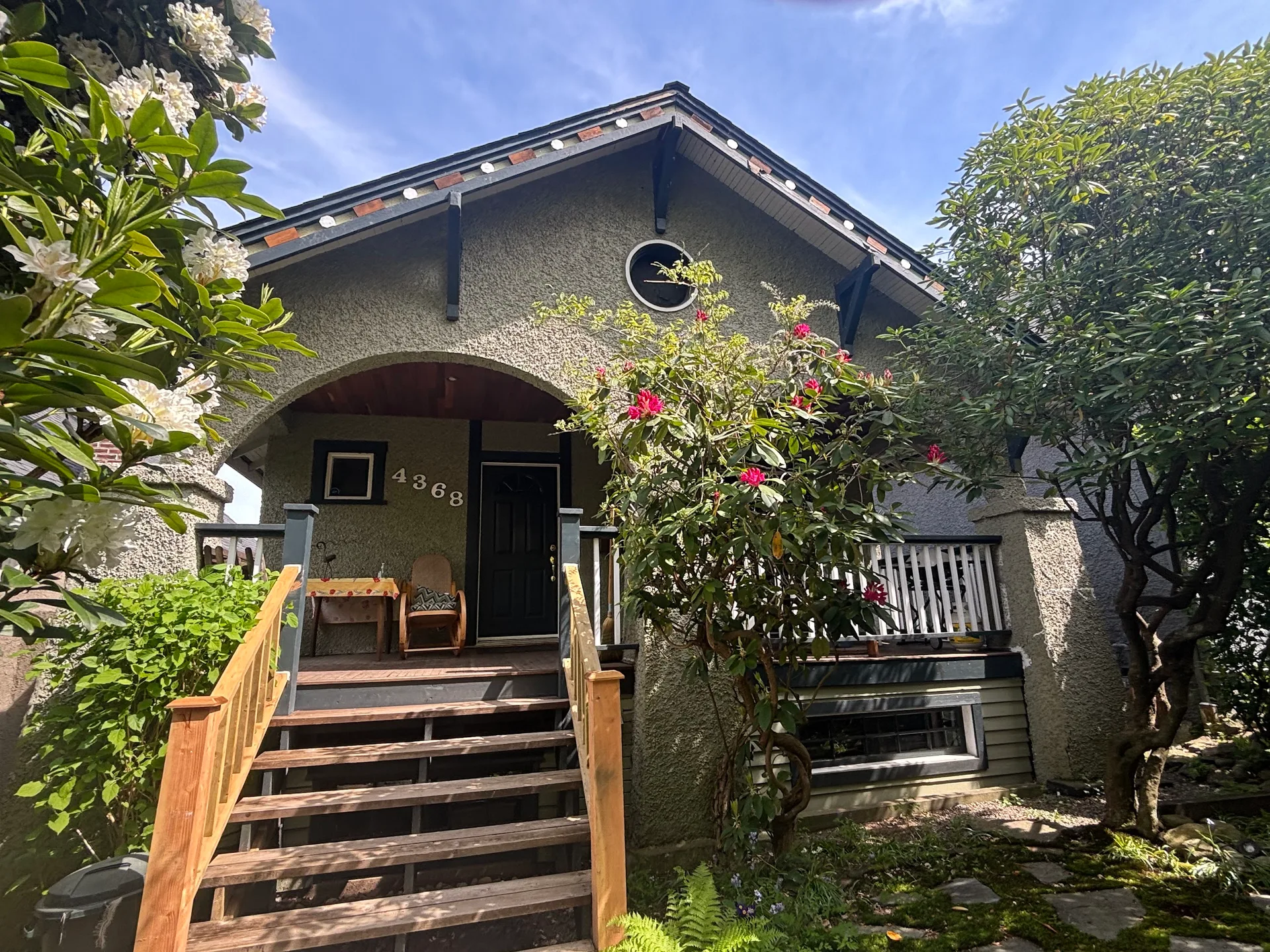 Before: Front elevation of house with arched porch entry, stairs, and garden, Vancouver, West Vancouver, BC
