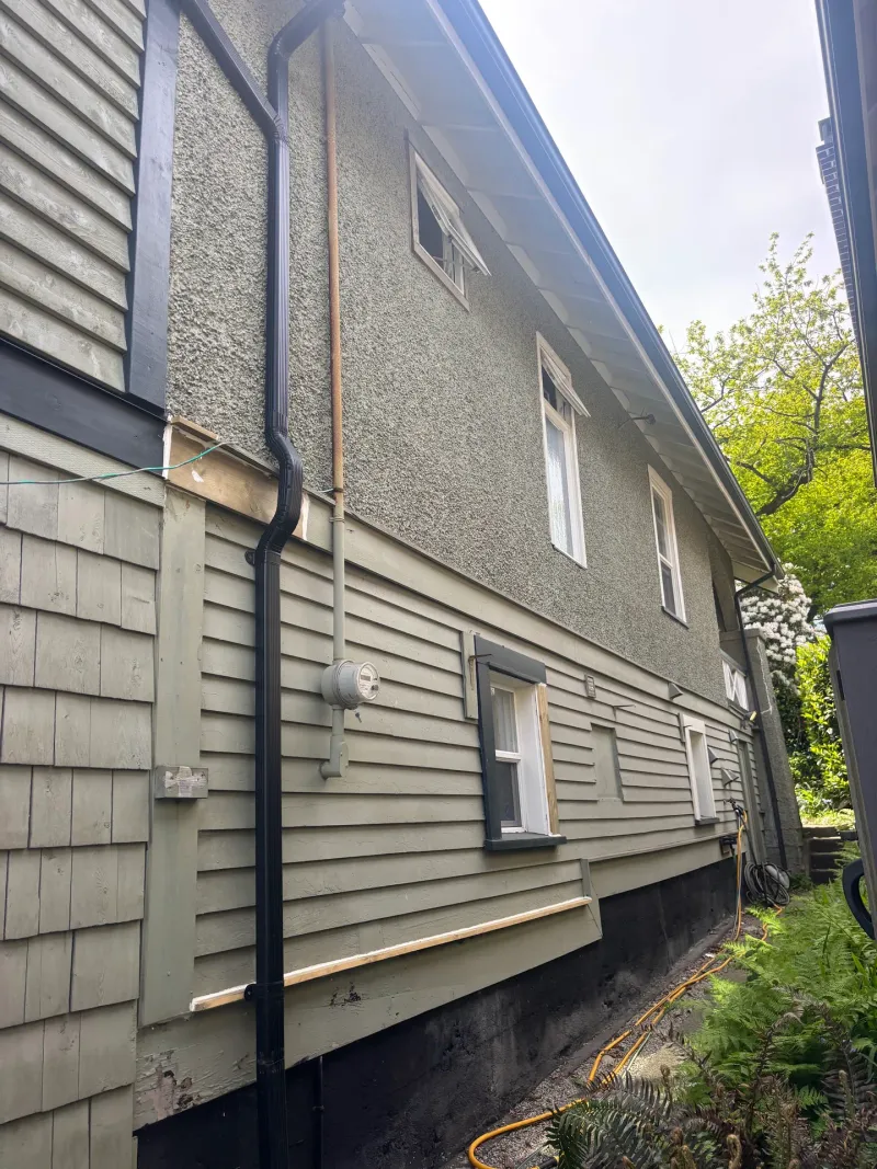 Before: Side elevation of house showing upper wall and lower siding before repainting, Vancouver, West Vancouver, BC