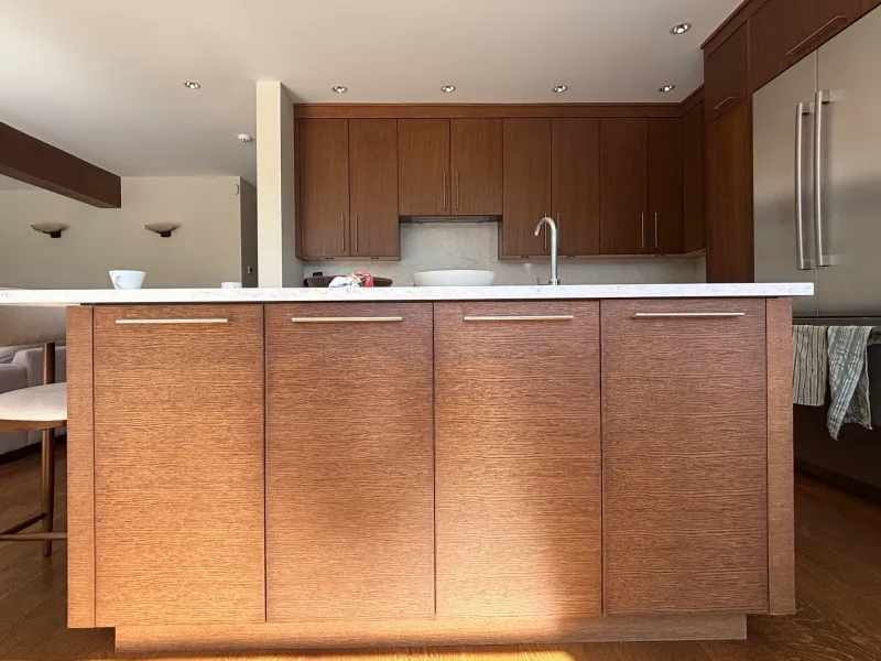 Before: Kitchen island cabinetry with long handles facing a countertop and sink area, Whistler, BC