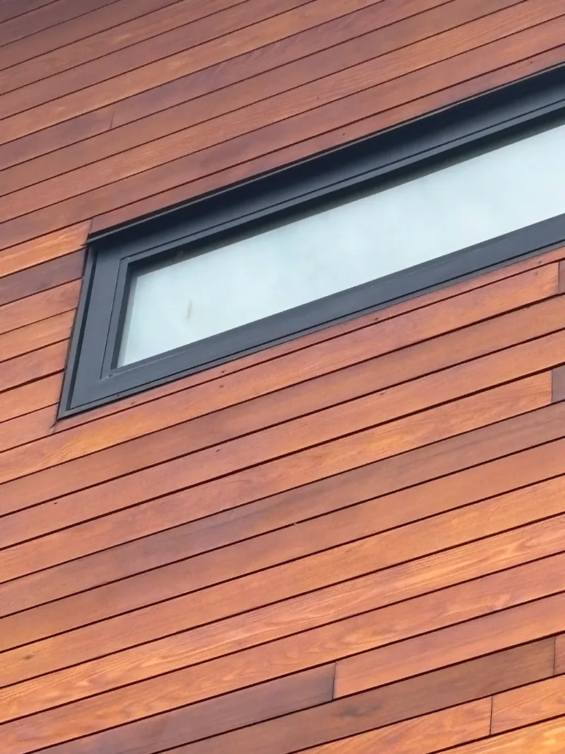 After: Close view of a window frame set into refinished siding, Whistler, BC