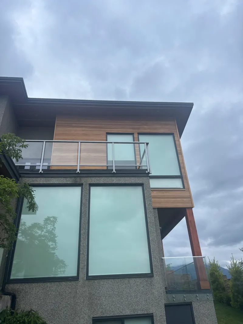 Before: Rear elevation corner with siding accent, glass balcony railing and large windows, Whistler, BC