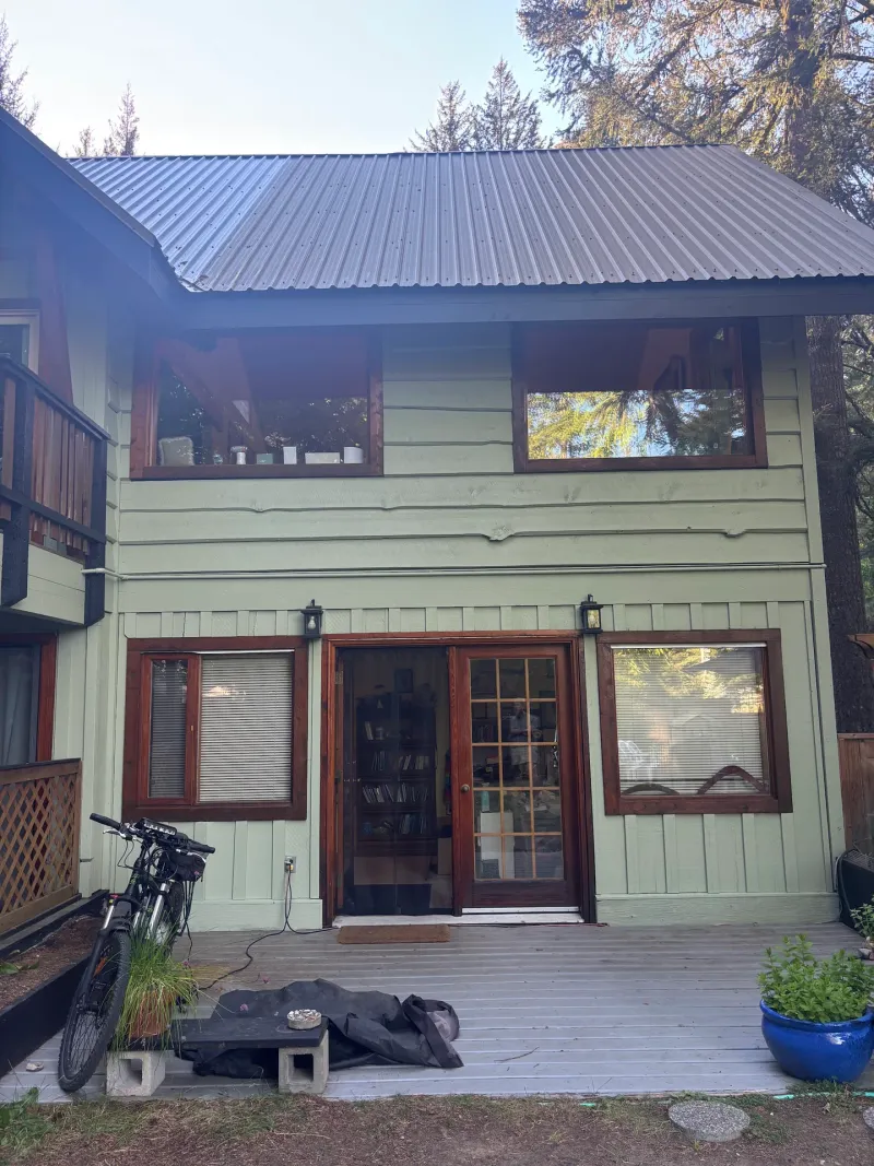 After: Rear elevation of house with French doors and upper windows after painting, Whistler, BC
