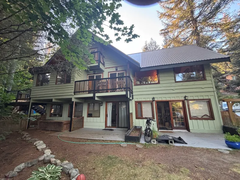 After: Rear elevation of house with deck, balcony, and multiple windows after painting, Whistler, BC