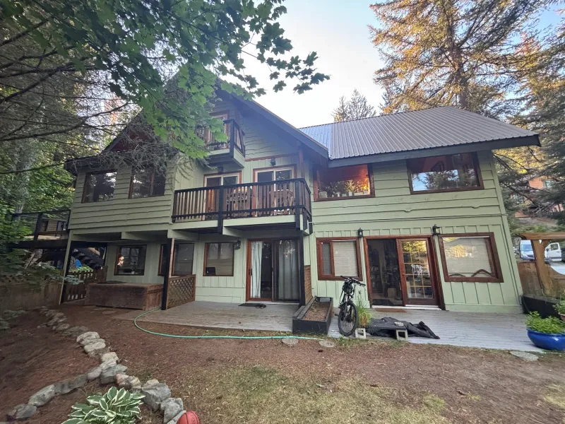 After: Rear elevation of house with deck, balcony, and multiple windows after painting, Whistler, BC